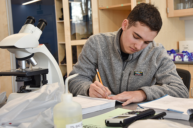 Student in science lab with microscope